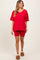 woman wearing a red oversized v-neck top and red biker shorts, paired with tan fuzzy slippers