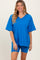 woman wearing a bright blue oversized v-neck t-shirt and matching bike shorts