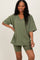 woman wearing an olive green oversized v-neck t-shirt with matching bike shorts
