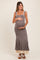 woman wearing a gray maternity dress with tie straps, fitted bodice, and flared skirt, holding her baby bump