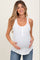woman wearing a white maternity tank top with button details and holding her baby bump