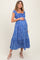 woman wearing a blue floral maternity dress with short sleeves and a baby bump visible
