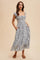 woman wearing a black and white floral maxi dress with a smocked bodice and pockets