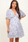 woman wearing a light blue floral maternity dress with short sleeves and a baby bump visible