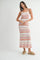 woman wearing a white and coral zigzag patterned maxi dress with spaghetti straps and tan slide sandals
