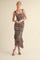 woman wearing a fitted leopard print midi dress with ruffle hem and thick straps, posing against a neutral background