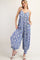 woman wearing a blue and white floral patterned jumpsuit with a loose fit and pockets