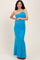 woman wearing a teal one-shoulder maternity gown, showing her baby bump with a decorative shoulder detail