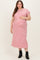 woman wearing a pink and white striped maternity plus maxi dress and holding her baby bump