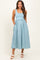 woman wearing a light blue maternity dress with a fitted bodice and full skirt, featuring side pockets