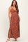 woman wearing a rust floral maternity maxi dress with side slits and a front tie detail, showing her baby bump