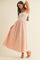 woman wearing a strapless pink maxi dress with a smocked bodice and flowy skirt