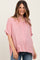 woman wearing a pink short sleeve button-up maternity shirt with a visible baby bump