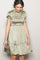 woman wearing an olive green smocked mini dress with puff sleeves and a tiered skirt