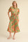 woman wearing a green floral midi dress with puff sleeves and a tie waist detail