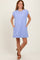 woman wearing a light purple oversized short sleeve dress with button details and side pockets