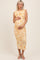 woman wearing a yellow and white tie-dye maternity dress, showing her baby bump with a fitted, ruched design
