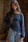 woman wearing a dark blue oversized knitted sweater and light blue high-waisted jeans