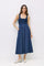 woman wearing a navy blue sleeveless maxi dress with a fitted bodice and gathered skirt, standing with hands in pockets