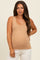 woman wearing a beige maternity tank top and showing her baby bump