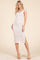 woman wearing a light pink floral midi dress with a fitted silhouette and side slit