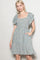 woman wearing a blue floral short sleeve dress with a square neckline and pockets