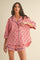 woman wearing a red and white checked pajama set with short sleeves and shorts, featuring floral accents