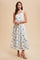 woman wearing a floral print midi dress with blue and white colors, featuring adjustable straps and a fitted bodice