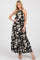 woman wearing a black and white floral maxi dress with a halter neck and flowing skirt