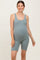 woman wearing a sage green ribbed maternity bodysuit, displaying her baby bump