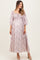 woman wearing a pink floral maternity maxi dress with puff sleeves and a visible baby bump