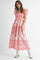 woman wearing a red and white floral maxi dress with short ruffled sleeves and a smocked bodice
