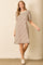 woman wearing a beige and brown striped short sleeve dress with puffed sleeves and a relaxed fit