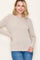 woman wearing a beige ribbed long sleeve top with a crew neckline and smiling