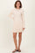 woman wearing a light beige long sleeve ribbed knit dress with a flared skirt and sandals