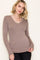 woman wearing a taupe long sleeve v-neck top paired with black jeans