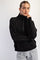woman wearing a black quarter-zip pullover sweatshirt with a relaxed fit and high collar, paired with gray sweatpants