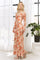 woman wearing a floral off-the-shoulder maxi dress with long sleeves and a fitted silhouette, standing next to a plant