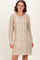 woman wearing a beige cable knit sweater dress with long sleeves and a relaxed fit