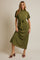 woman wearing a green midi dress with a tie belt and short sleeves, standing against a neutral background