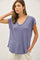 woman wearing a purple short sleeve v-neck top with a relaxed fit and side pockets