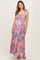woman wearing a flowing floral maternity maxi dress with adjustable straps and holding her baby bump