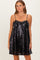 woman wearing a black sequin mini dress with a bow detail and spaghetti straps