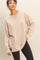 woman wearing a light beige oversized long sleeve sweatshirt paired with black skinny jeans