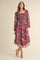 woman wearing a burgundy floral maxi dress with puff sleeves and smocked bodice