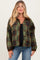 woman wearing a green and brown plaid maternity jacket with a relaxed fit and button closure over a black top