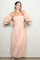 woman wearing a pink off-the-shoulder lace maxi dress with puff sleeves, posing with hands on hips
