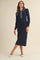 woman wearing a navy ribbed long sleeve midi dress with a decorative collar and styled with ballet flats