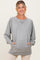 woman wearing a grey maternity pullover sweatshirt with side pockets and ribbed detailing