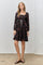 woman wearing a black floral print short dress with puff sleeves and a tied waist detail